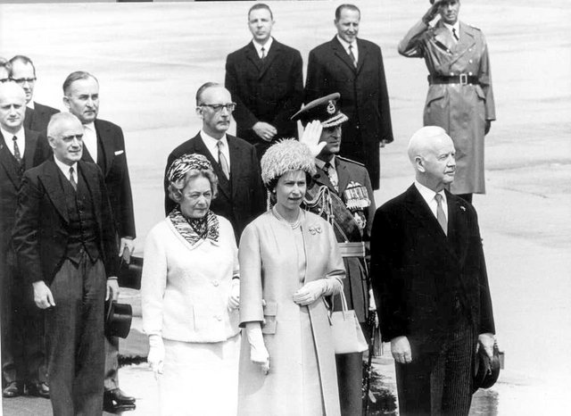 Queen Elisabeth steht von Würdenträgern umrandet auf dem Vorfeld.