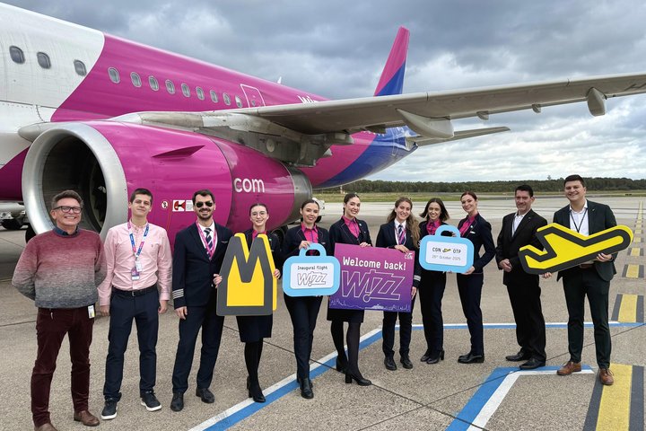 Mitarbeiter des Flughafens begrüßen die Airline Crew vor einer Wizz Air Maschine.