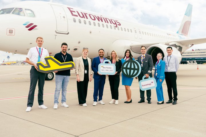 Mitarbeiter des Flughafens begrüßen den Erstflug mit der Eurowings Crew vor einem Flugzeug auf dem Vorfeld.
