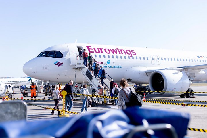 Passagiere steigen in ein Eurowings Flugzeug.