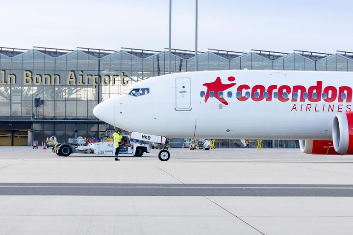 Eine Boeing 737 von Corendon Airlines auf dem Vorfeld, das Terminal 2 des Flughafens im Hintergrund.