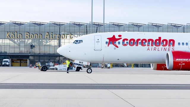 Eine Boeing 737 von Corendon Airlines auf dem Vorfeld, das Terminal 2 des Flughafens im Hintergrund.