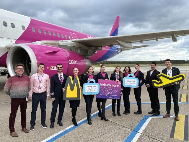 Mitarbeiter des Flughafens begrüßen die Airline Crew vor einer Wizz Air Maschine.