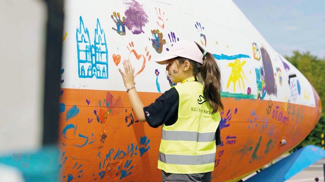 Kind bemalt Flugzeug am Weltkindertag mit Fingerfarbe
