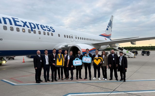 Mitarbeiter des Köln Bonn Airport Marketing und er SunExpress Crew stehen vor einem SunExpress Flugzeug