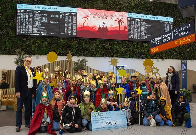 Als Sternsinger verkleidete Kinder versammeln sich im Terminal des Flughafens